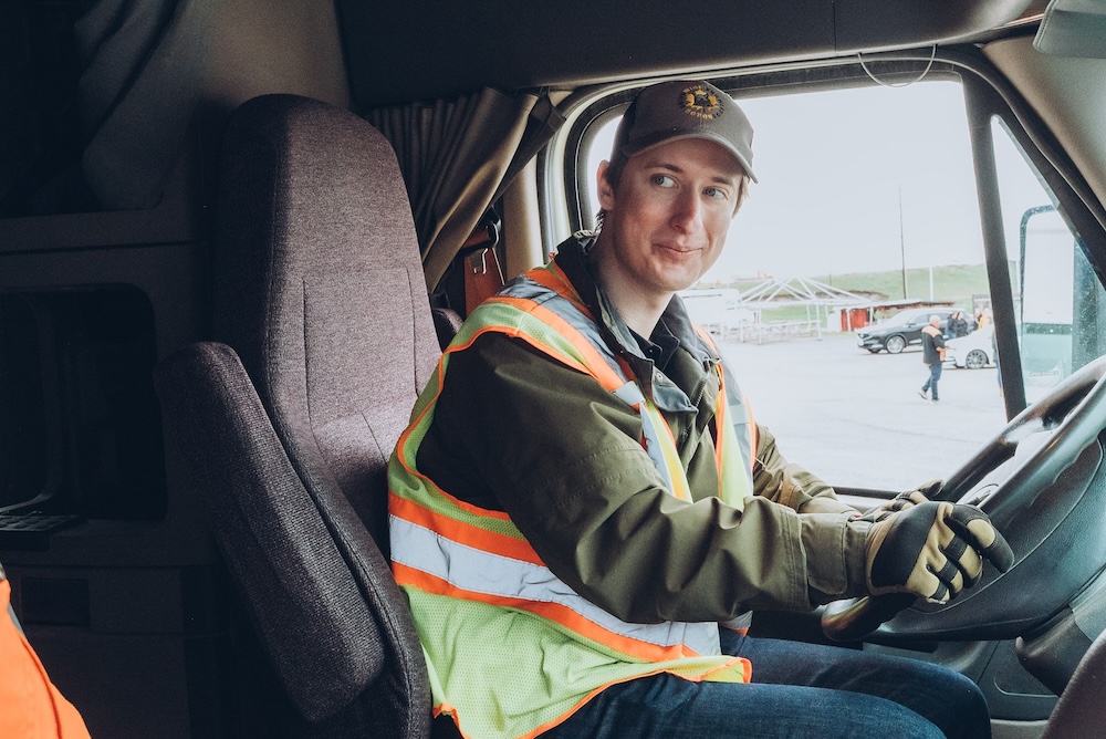 Student-truck-driver-smiling-KnowledgeSurge A student of KnowledgeSurge looking at a notebook.